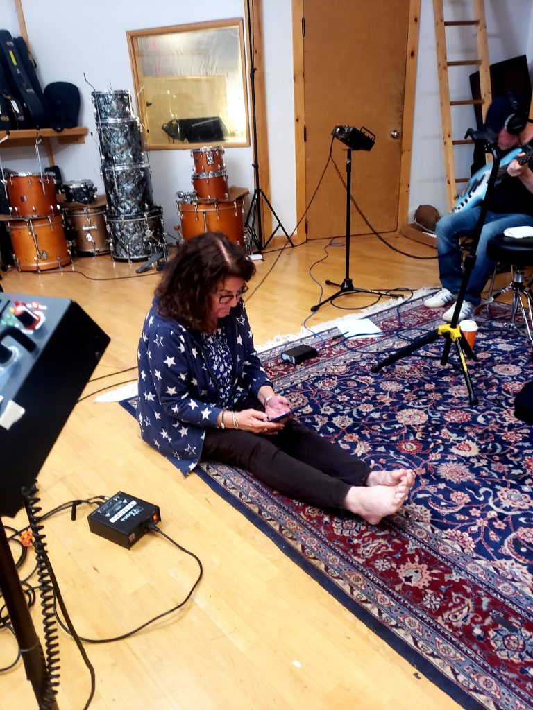 Robin Lindahl sitting on rug near bass player.